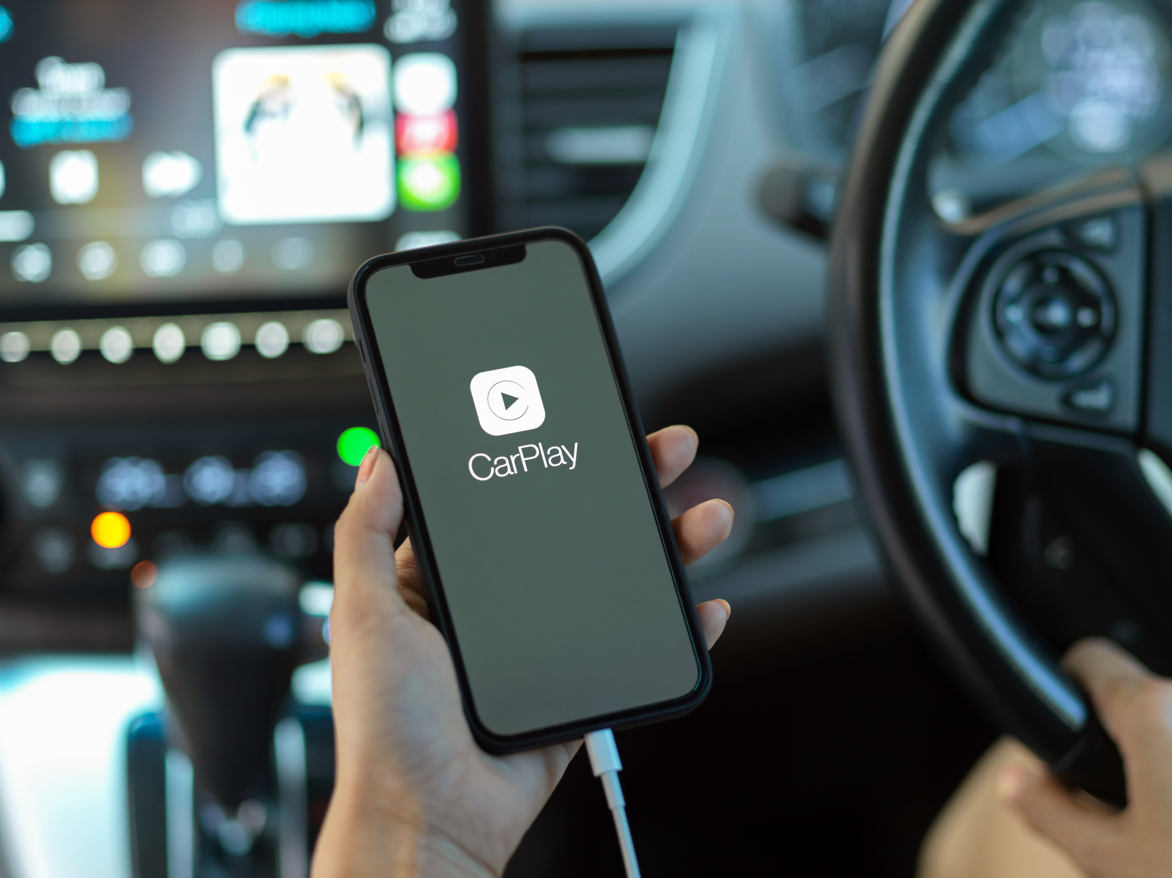 CHIANG MAI, THAILAND - MAY 11, 2020 : hand holding smartphone with CarPlay application. CarPlay is a application allows you to view content from your iPhone on your car's infotainment screen